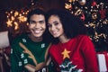 Photo of two lovers girl guy enjoy new year event occasion in cozy illuminated ornament house indoors