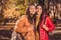 Photo of two people girls friends enjoy travel city nature countryside center hug embrace wear outerwear hold bag Royalty Free Stock Photo