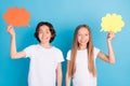 Photo of two positive children hold mind bubble share opinion wear white t-shirt isolated blue color background