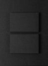 Photo of two stack Of blank black business cards on textile background. Vertical