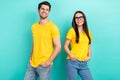 Photo of two teammates partners yellow t-shirts denim jeans hands pockets stylish ray ban glasses good job isolated on Royalty Free Stock Photo