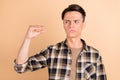 Photo of uncertain unsure suspicious guy look side talk hand wear plaid shirt isolated beige color background