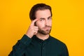 Photo of uncertain upset young guy dressed smart casual clothes finger head temple isolated yellow color background