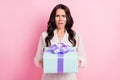 Photo of unhappy displeased young woman get gift dislike shocked amazed isolated on pastel pink color background