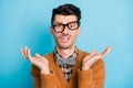 Photo of unhappy puzzled young man raise hands wear glasses bad mood isolated on pastel blue color background Royalty Free Stock Photo