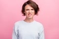 Photo of unhappy upset angry young woman bad mood angry face aggressive isolated on pink color background