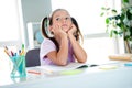 Photo of unsatisfied minded schoolkid sit chair hands touch cheeks look curious away ponder flat indoors Royalty Free Stock Photo