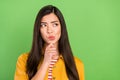 Photo of unsure brown hairdo young lady look empty space wear yellow shirt isolated on green color background