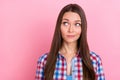 Photo of unsure brunette millennial lady look empty space wear blue shirt isolated on pastel pink color background