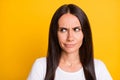 Photo of unsure doubtful young woman dressed white t-shirt looking empty space isolated yellow color background