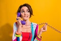 Photo of unsure suspicious woman dressed striped suit talking land line phone biting lip empty space isolated yellow