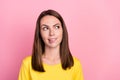 Photo of unsure thoughtful young woman dressed yellow t-shirt biting lip looking empty space isolated pink color