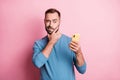 Photo of unsure young guy wear blue pullover looking modern gadget arm chin isolated pink color background