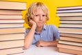 Photo of upset bored schoolboy sitting desk having read many book hand arm cheekbone cheek isolated yellow color