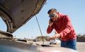 Photo of upset man with phone in next to open hood of broken car in daytime Royalty Free Stock Photo