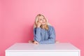 Photo of upset unsure woman wear pullover sitting office looking empty space isolated pink color background Royalty Free Stock Photo
