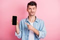 Photo of upset young brunette man point finger index screen phone feedback isolated on pink color background