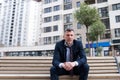 Photo Upset Young Businessman Sitting On Bench. Disappointed businessman sitting on a wooden bench with bottle in his hand in