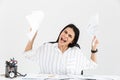 Photo of uptight brunette businesswoman 30s screaming and stressing while working with paper documents in office