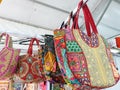 Photo of variety of colorful Rajasthani artwork handbags hanging in the store for sale
