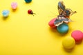 A photo of various macaroons and a butterfly, roses, ladybug. shot from above, on a yellow background with a place for text