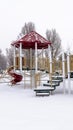 Photo Vertical Colorful playground for children at a park covered with snow at winter season Royalty Free Stock Photo