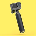Photo and video lightweight black action camera with monopod on yellow