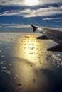 View of the sea through the window of an airplane with sun reflection in the water and flare of water droplets on the glass Royalty Free Stock Photo