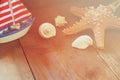 Photo of vintage decorative boat, sea shells and starfish on wooden old table. retro filtered image. marine background Royalty Free Stock Photo