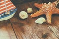 Photo of vintage decorative boat, sea shells and starfish on wooden old table. retro filtered image. marine background Royalty Free Stock Photo