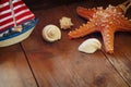 Photo of vintage decorative boat, sea shells and starfish on wooden old table. retro filtered image. marine background Royalty Free Stock Photo