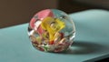 A photo of a vintage paper weight made of blown glass with flowers and bubbles inside.