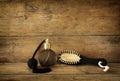 Photo of vintage perfume bottle next to old wooden hairbrush on wooden table. retro filtered image