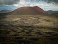 Photo of a volcanic landscape with a red crater in the background Royalty Free Stock Photo