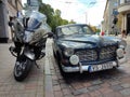 Photo of a Volvo car and a black motorcycle next to each other in the streets of Riga, Latvia