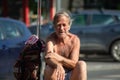 Old man sitting in the middle of the street Royalty Free Stock Photo