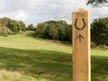 Permissive horse track direction signpost with horse shoe and arrow on wooden post