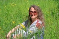 A young woman in sunglasses is relaxing on the lawn enjoying the warm rays of the spring sun Royalty Free Stock Photo