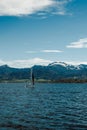 Sailboats on Lake Chiem and snow-capped mountains in the distance