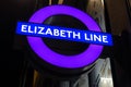 Illuminated Elizabeth Line purple London Underground tube station sign