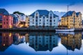 City Scene with Traditional Houses and Boat Reflected in A Calm Canal at Night in Alesund