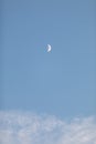 Photo of a Waxing Crescent Half Moon in the Clouds with Blue Sky