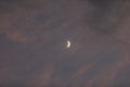 Photo of a Waxing Crescent Half Moon in the Clouds