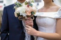 Photo of wedding bouquet in hands of groom and bride.