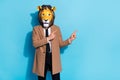 Photo of weird crazy guy lion mask point finger empty space demonstrate mardi gras ads  over blue color Royalty Free Stock Photo
