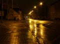 Wet empty street at night illuminated by street lamps Royalty Free Stock Photo