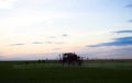 Photo of a wheat field Spraying a tractor with agrochemical or agrochemical preparations over a young wheat field in Royalty Free Stock Photo