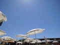 White beach umbrellas against the blue sky. Marfa, Mellieha, Malta Royalty Free Stock Photo