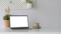 Photo of white blank screen computer laptop putting on white working desk that surrounded by coffee cup. Royalty Free Stock Photo