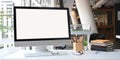 Photo of white blank screen computer monitor, wooden pencil holder, stack of books, wireless mouse and keyboard. Royalty Free Stock Photo